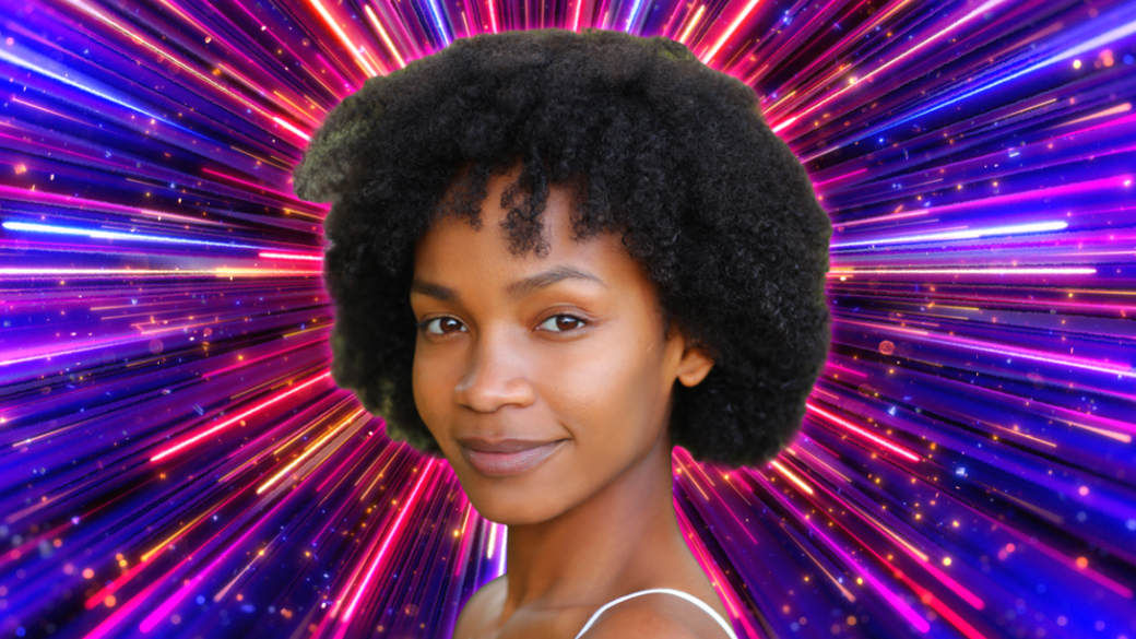 Bethany Antonia head shot, she is smiling and looking at the camera with a firework backdrop behind her.