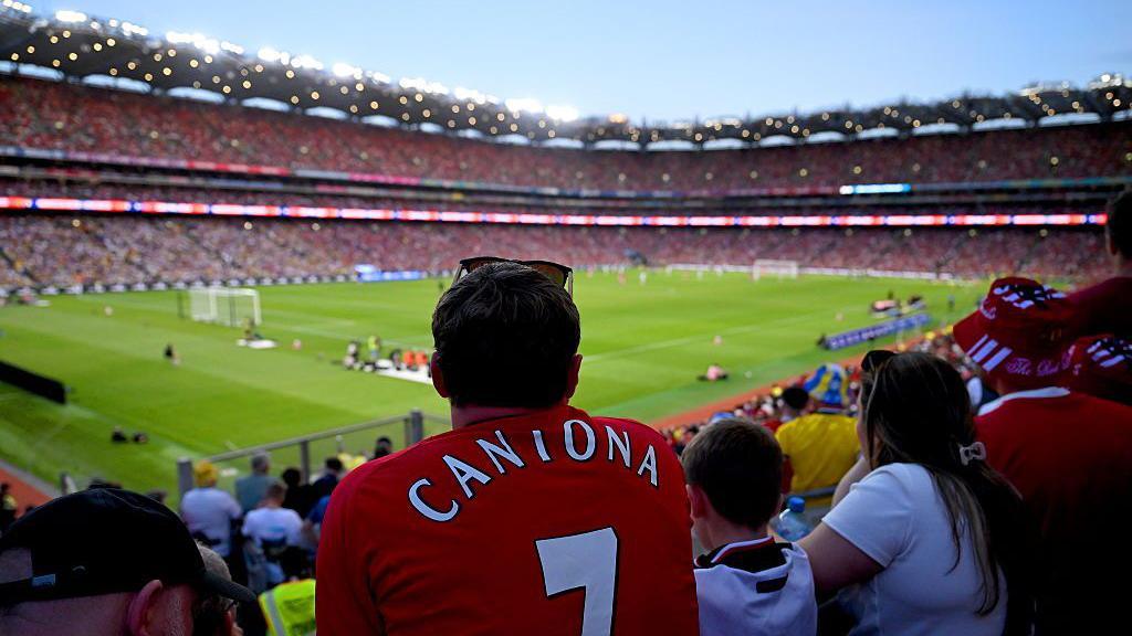 An Irish supporter wearing a Manchester United jersey with Cantona on the back