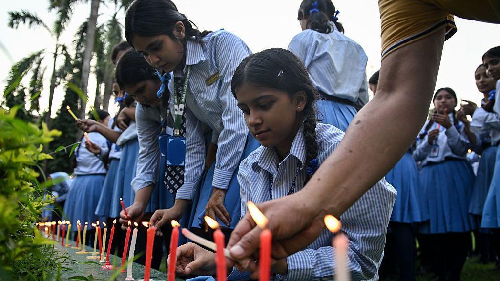 Mourners and students light candles to offer their condolences after the death of mountaineer Nirmal Purja and his companions in an avalanche in Pakistan