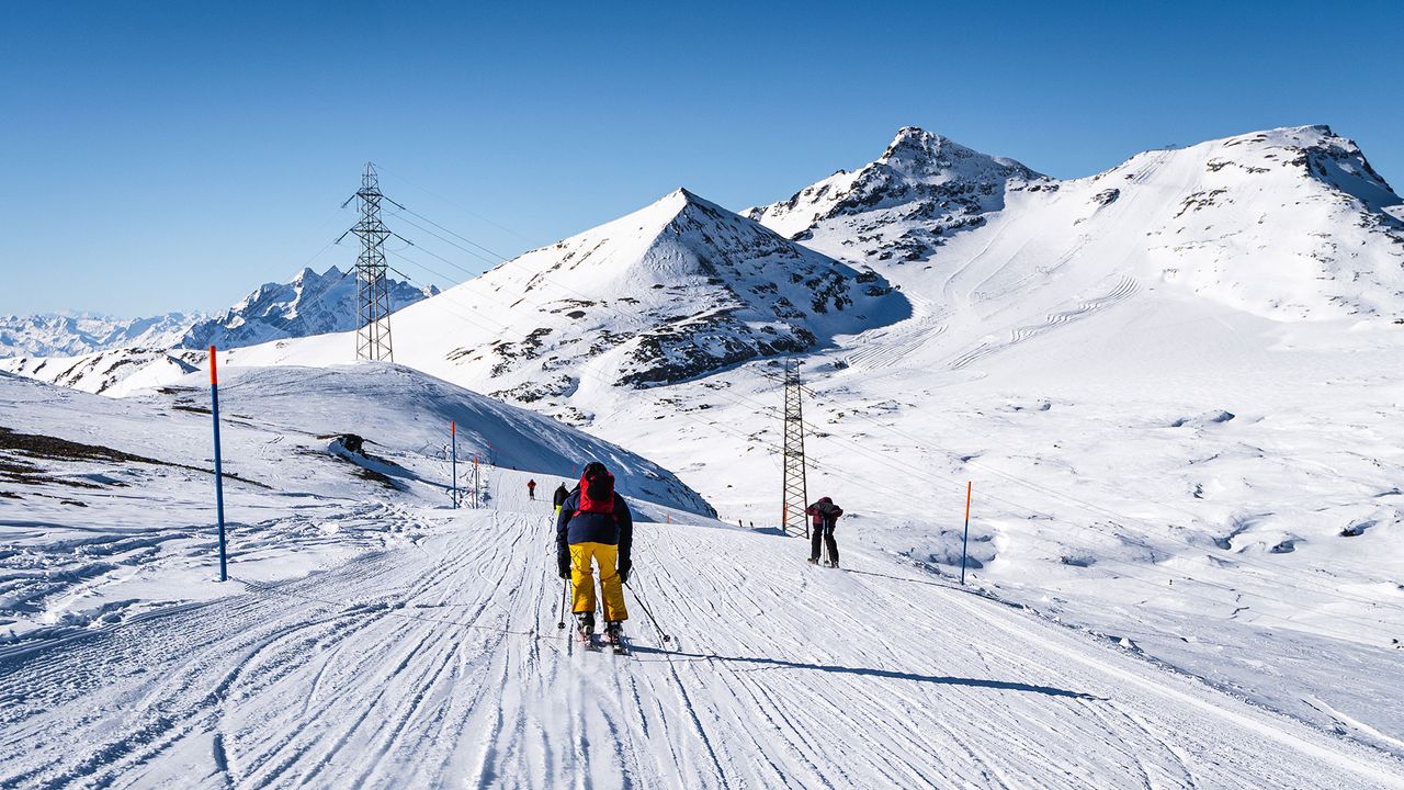 Skiers skiing down hill near Hotel Maiensee