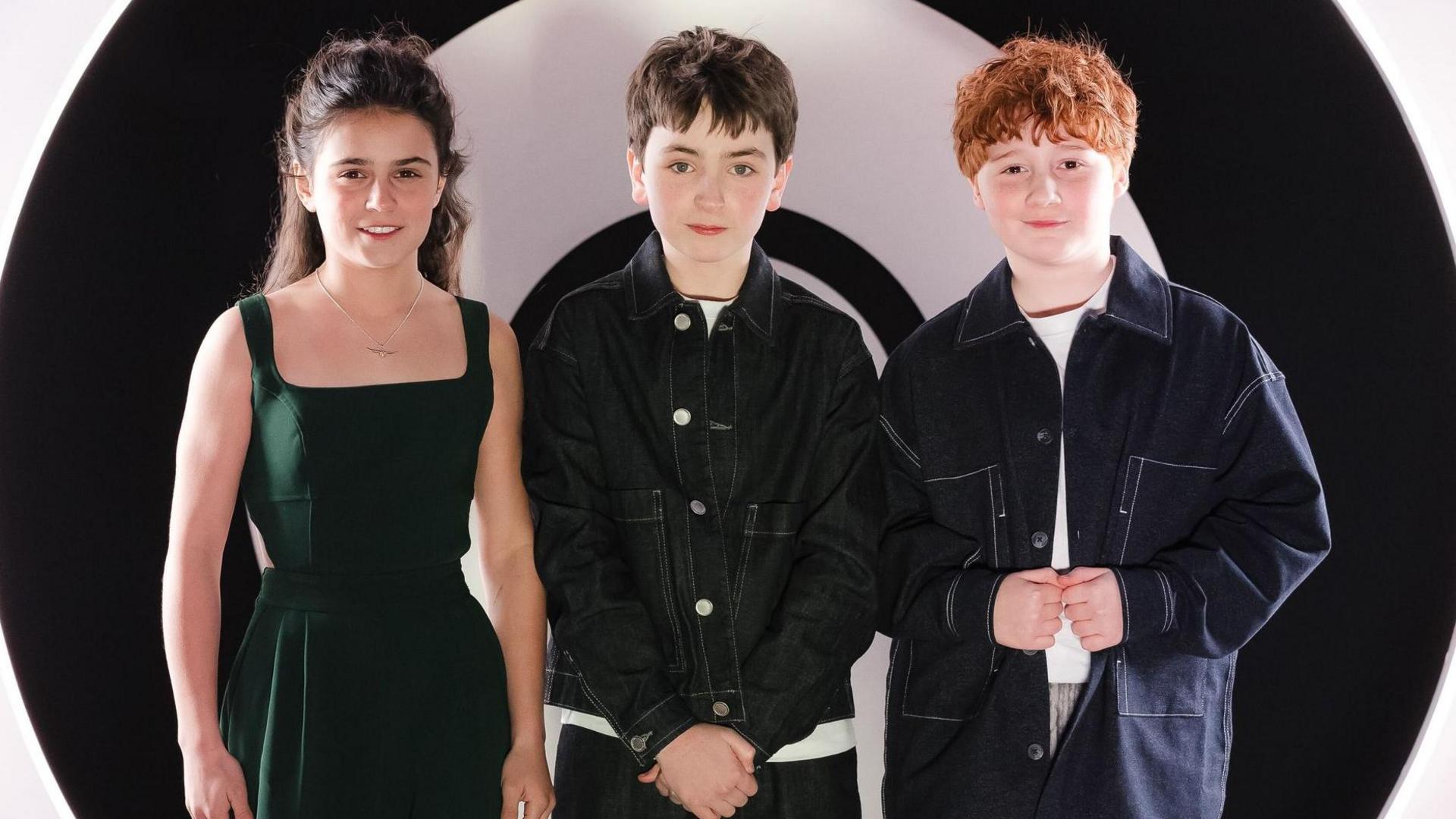Arabella Stanton, Dominic McLaughlin and Alastair Stout standing together ina promotional photo and not in costume