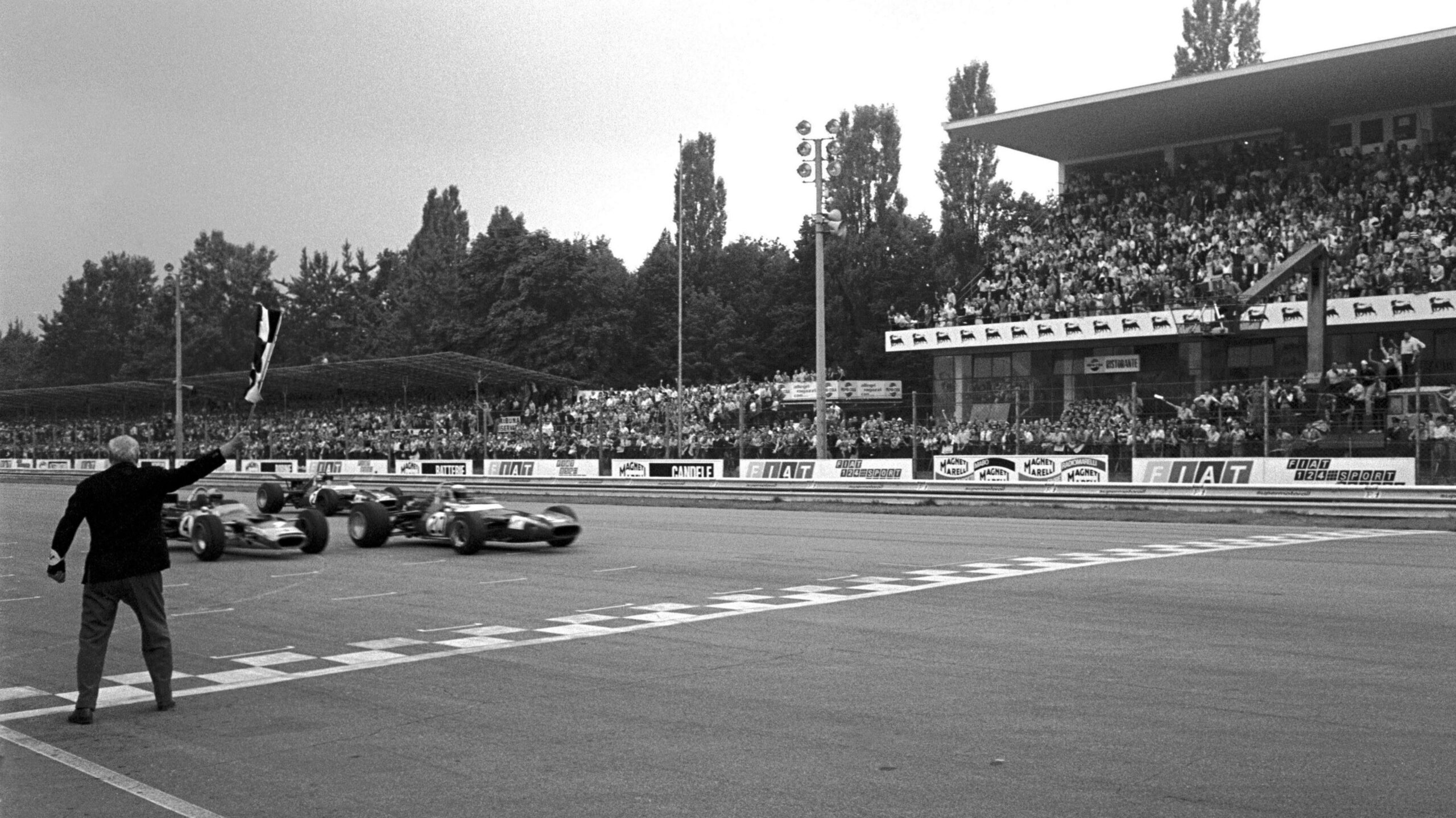 Matra's Jackie Stewart crosses the line to win the 1969 Italian Grand Prix just ahead of Jochen Rindt's Lotus and Jean Pierre Beltoise