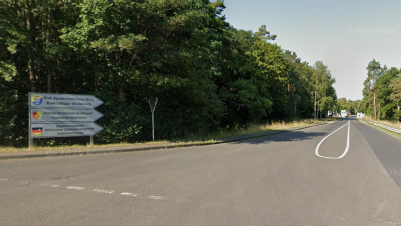 A sign leading to Mechernich military base, with the entry checkpoint visible in the distance.
