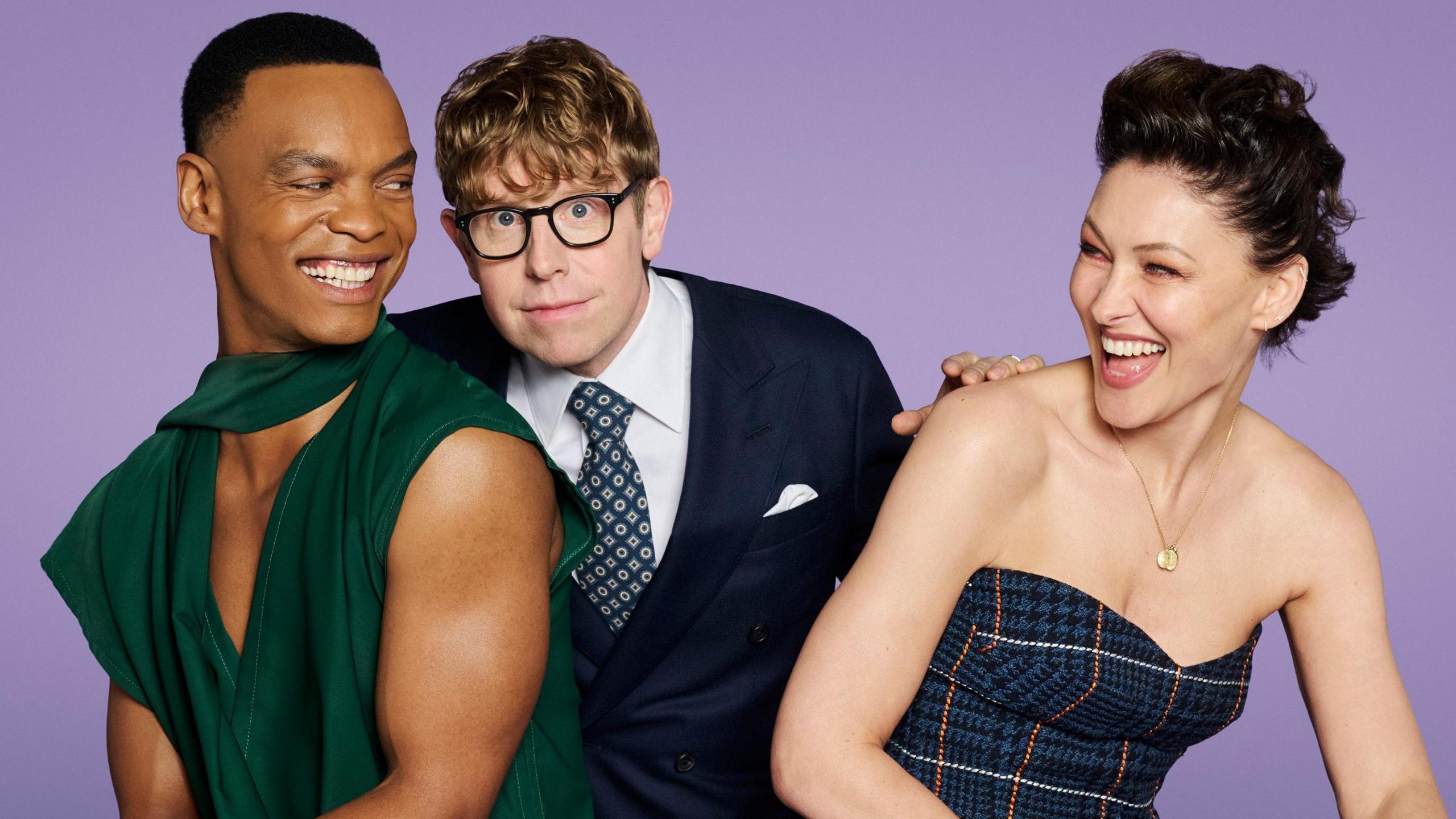 Josh Widdicombe, Emma Willis and Johannes Radebe holding glitter balls against a purple background