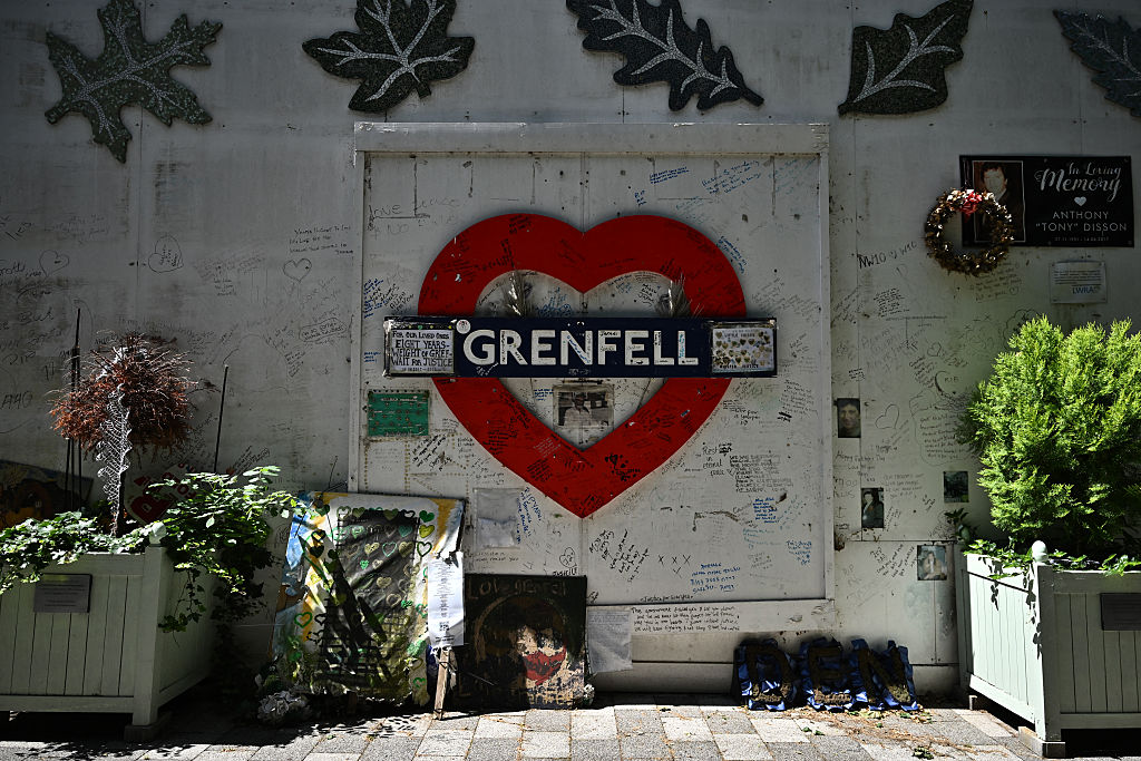 Tributes are seen on the fence surrounding the remains of the residential tower block Grenfell Tower in west London