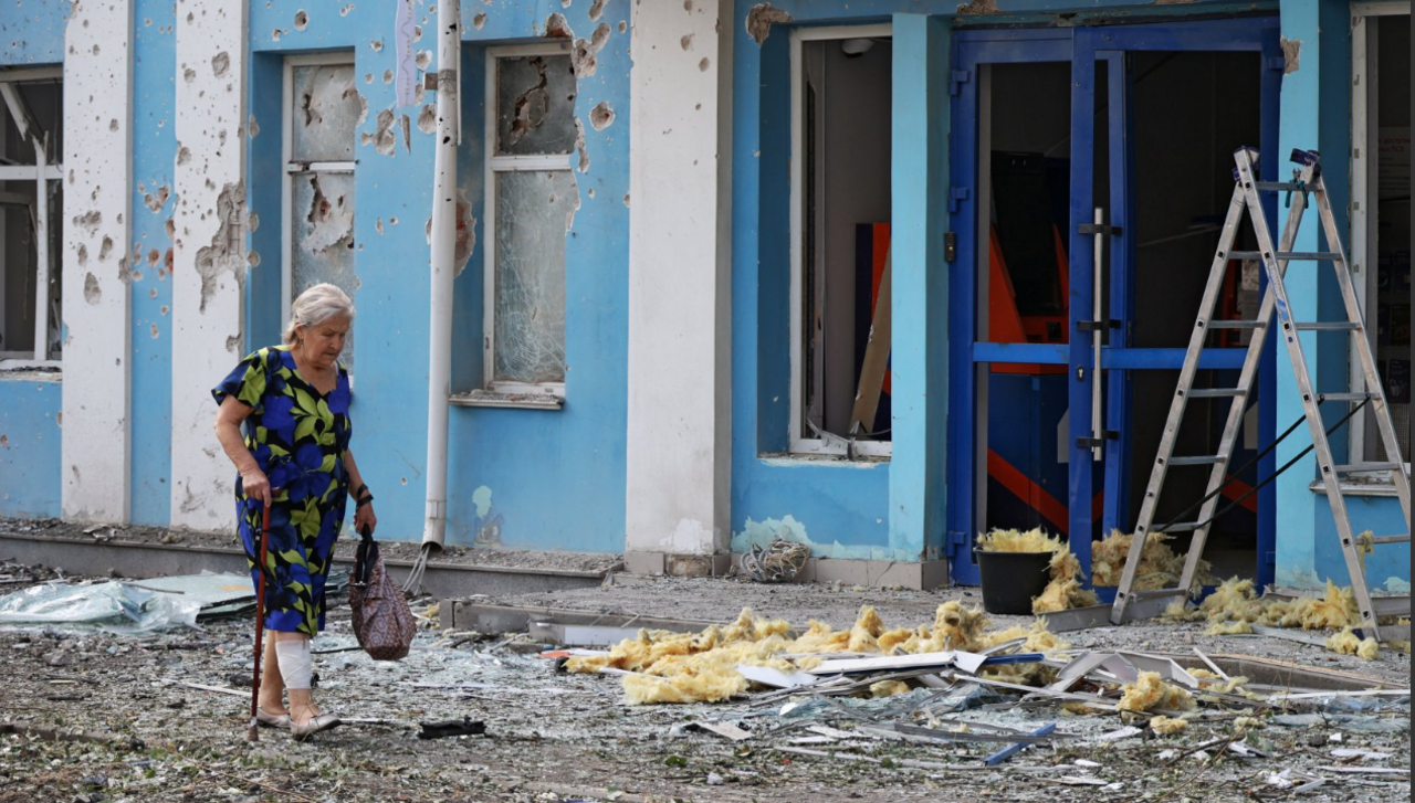 A woman walks past a bank building damaged during a Ukrainian overnight drone attack in Belgorod, Russia on 9 August
