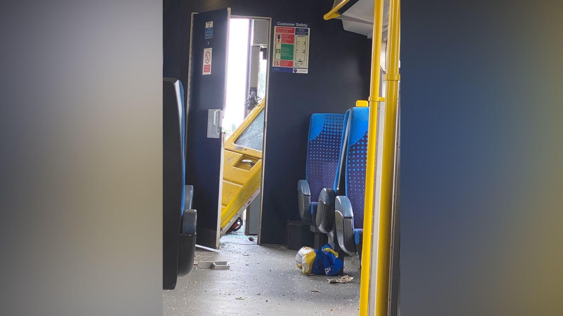 Image shows a train door sheered off its hinges in the driver's cab of the train