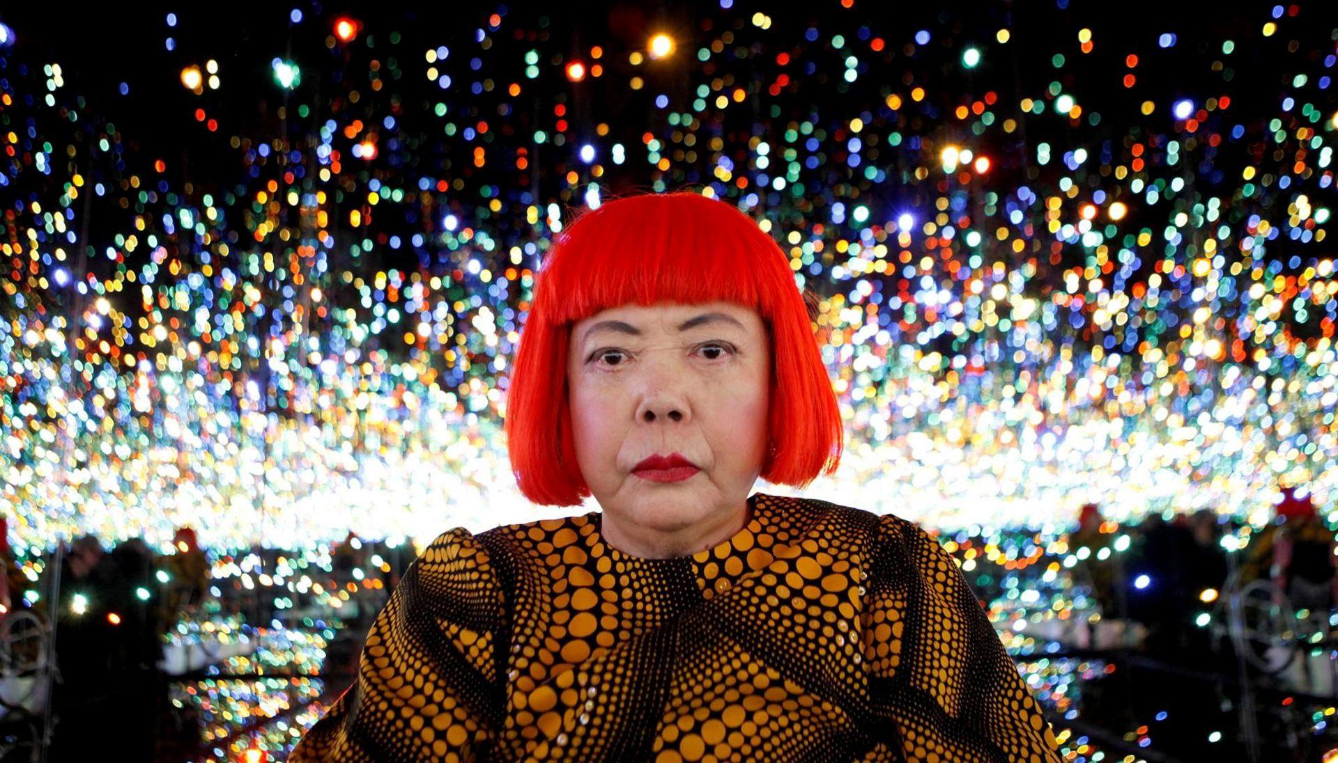 Japanese artist Yayoi Kusama poses for a photograph inside her Infinity Mirrored Room installation titled "The Souls of Millions of Light Years Away" during a media preview of her new exhibition at the David Zwirner gallery in New York, U.S.