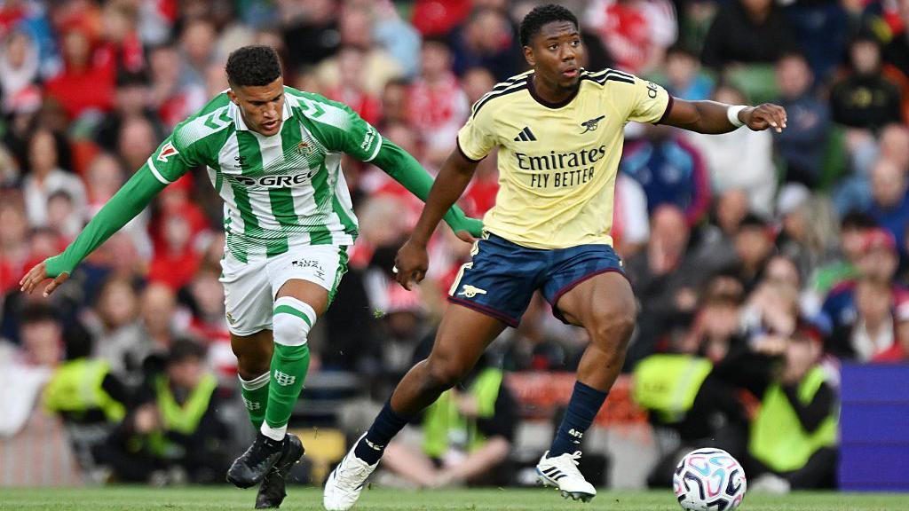 Myles Lewis-Skelly dribbles away from Real Betis' Nelson Deossa