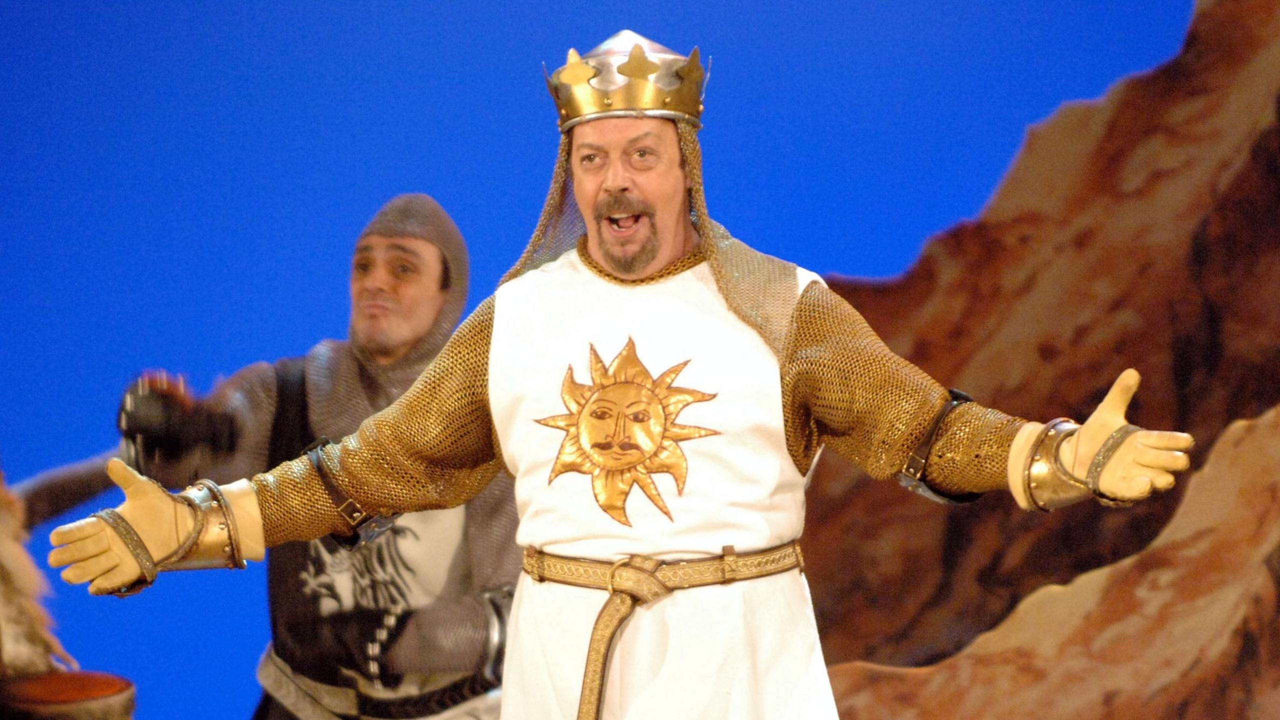 Tim Curry in costume on stage in Spamalot