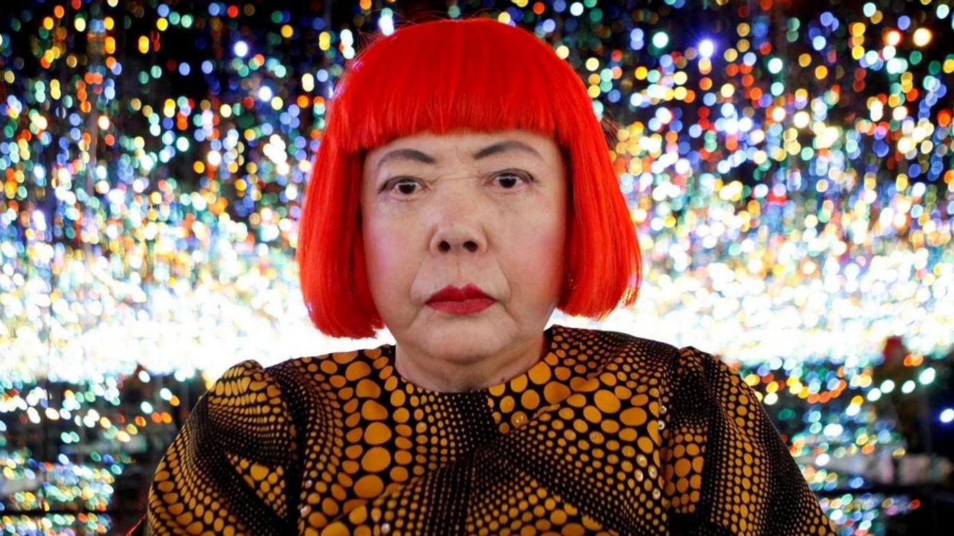 Japanese artist Yayoi Kusama poses for a photograph inside her Infinity Mirrored Room installation titled "The Souls of Millions of Light Years Away" during a media preview of her new exhibition at the David Zwirner gallery in New York, U.S.