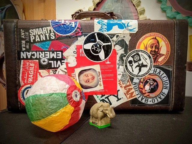 A brown trumpet case covered in stickers