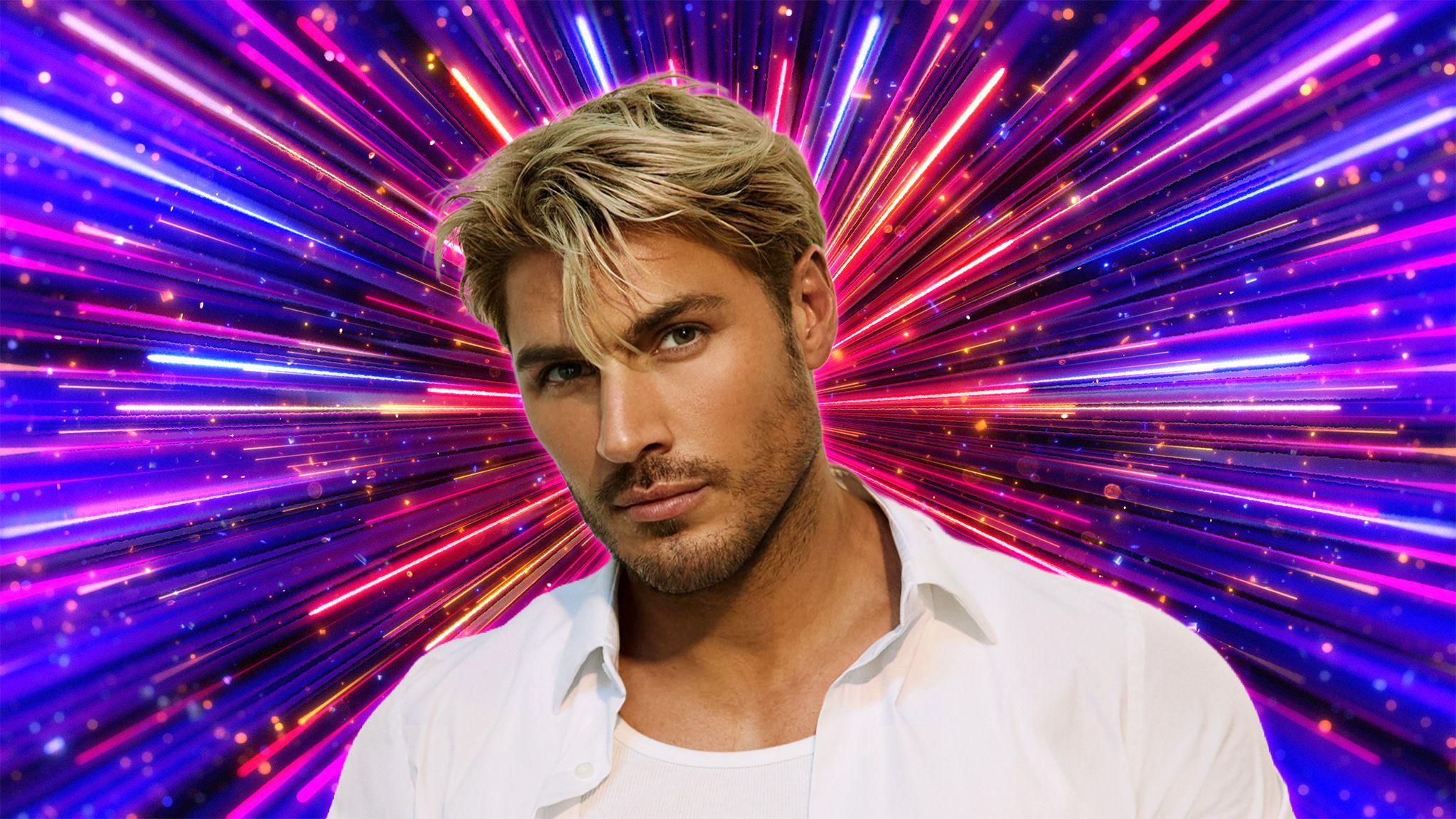 Chris Appleton, dressed in white, looking into the camera with fireworks going off behind him