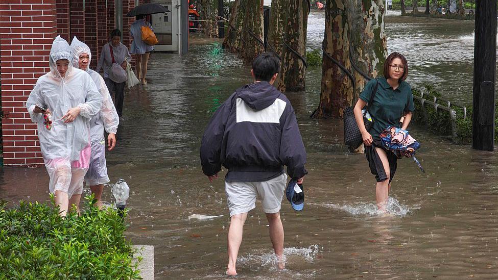 Residents wade through flooded streets in Shanghai