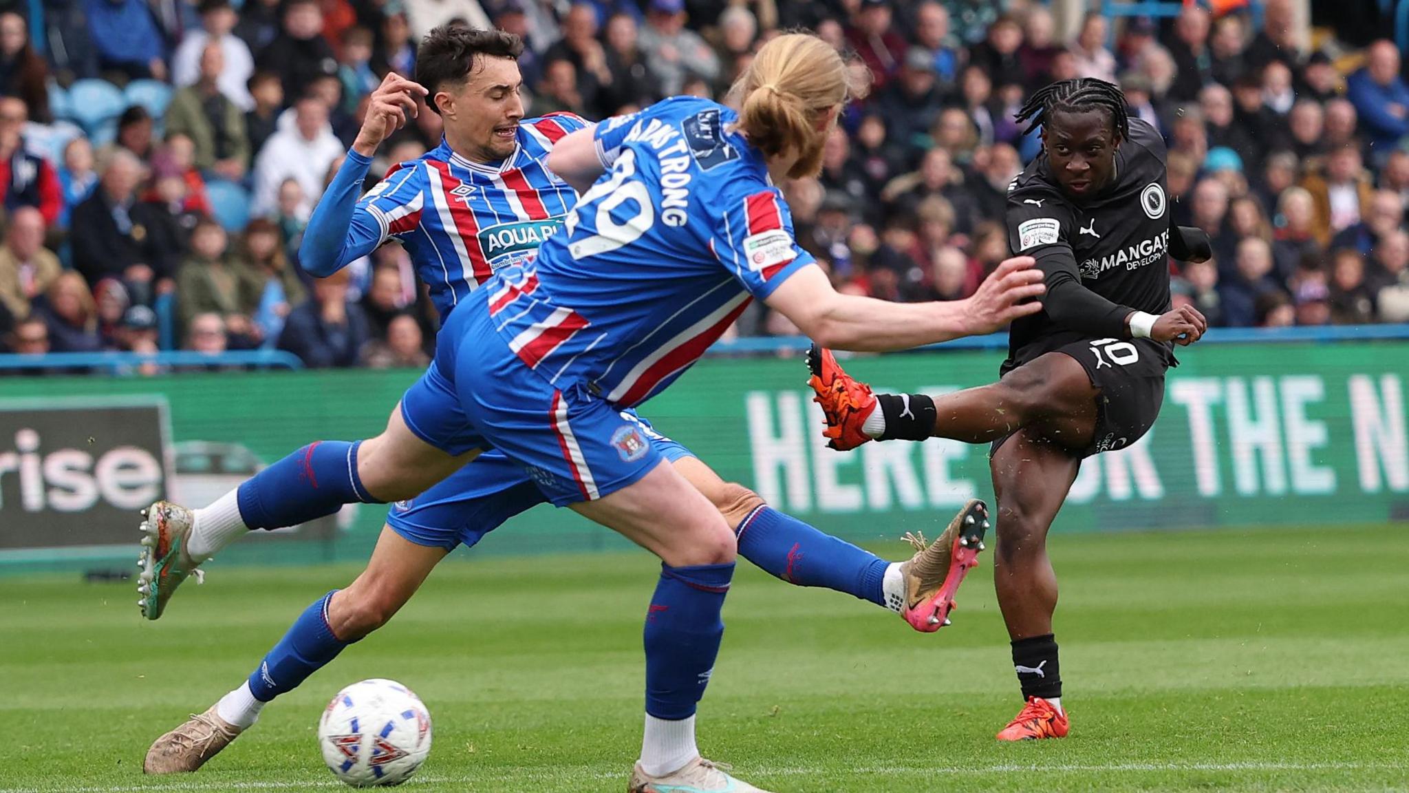 Abdul Abdulmalik shoots a football for Boreham Wood against Carlisle United