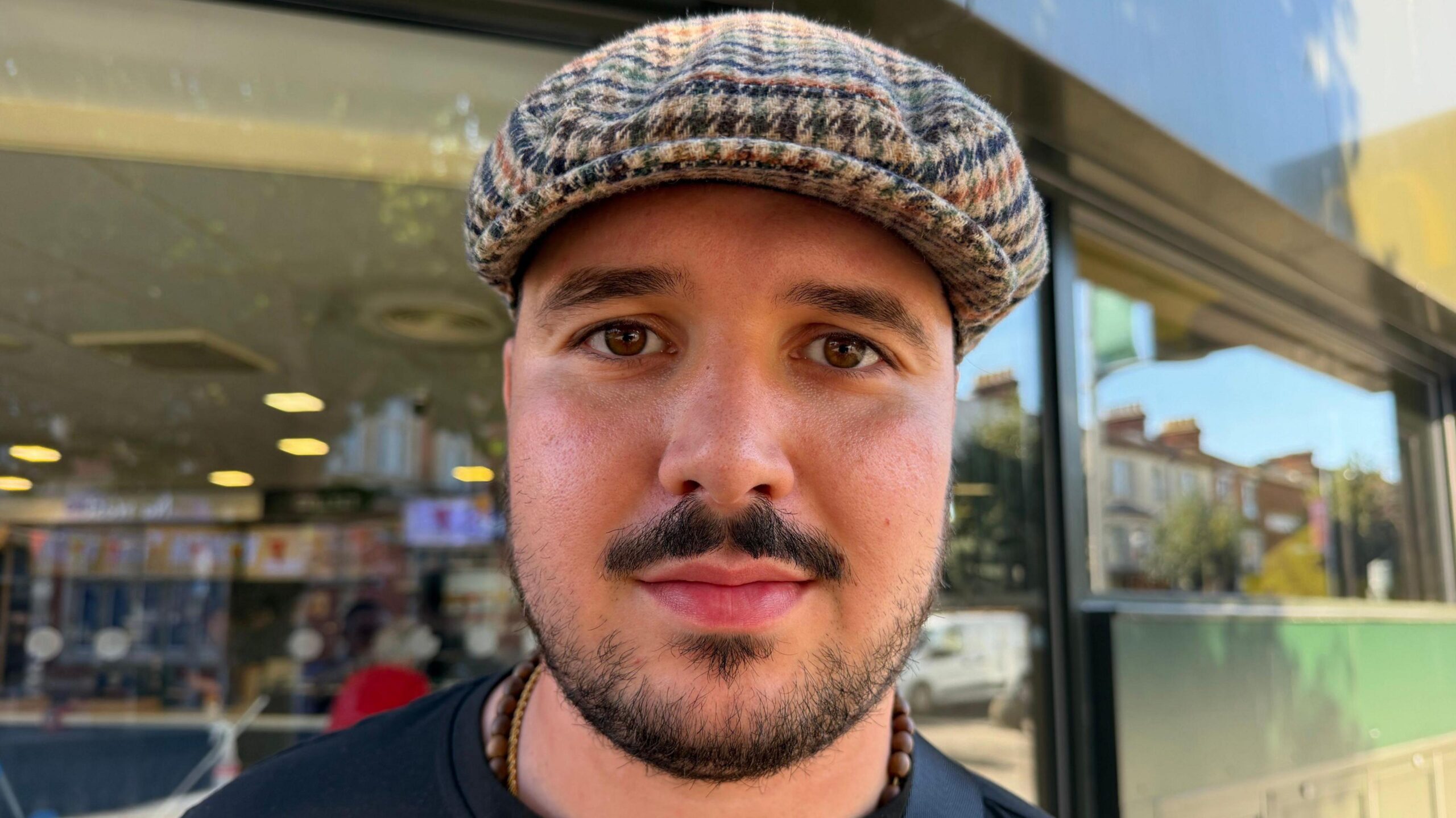 Zak Apsey is wearing a checkered cap and a dark T-shirt in Clacton.