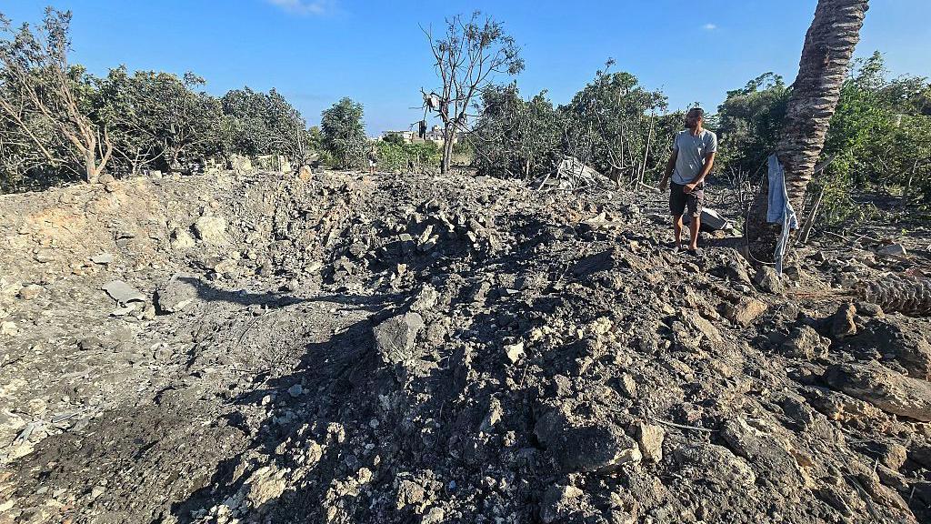 A man stands by a crater left by an overnight Israeli air strike on a house in the area of Burj al-Shamali, near Tyre, southern Lebanon (6 August 2026)