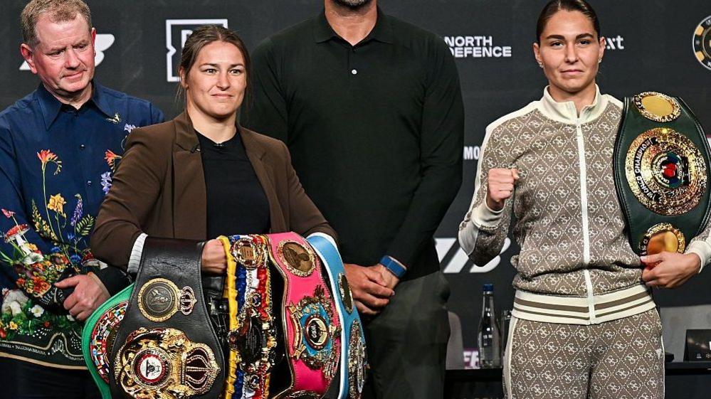 Katie Taylor holds the WBO, WBA and IBF light-welterweight titles and stands next to Flora Pili