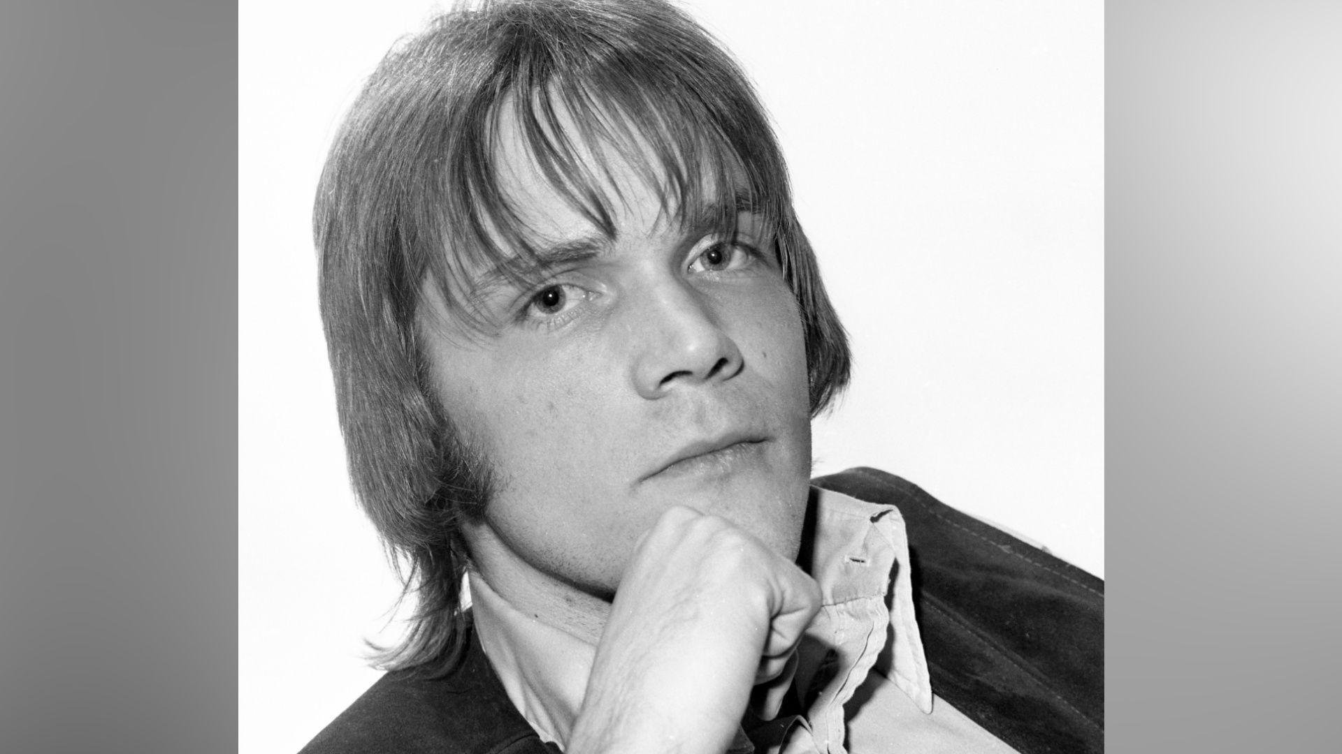 Brian Hyland in the 1970s. He is pictured in black and white, and has medium length hair. He sat with his hand resting on his chin.