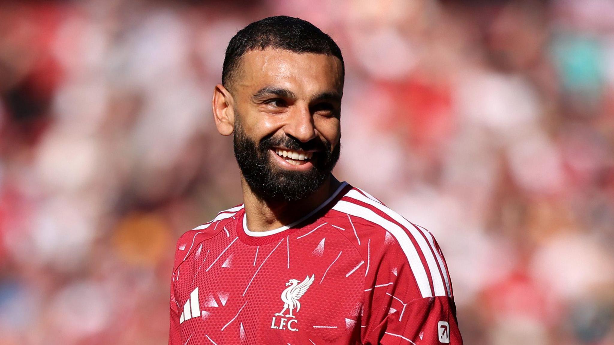 Liverpool's Mohamed Salah smiles while playing in the Premier League