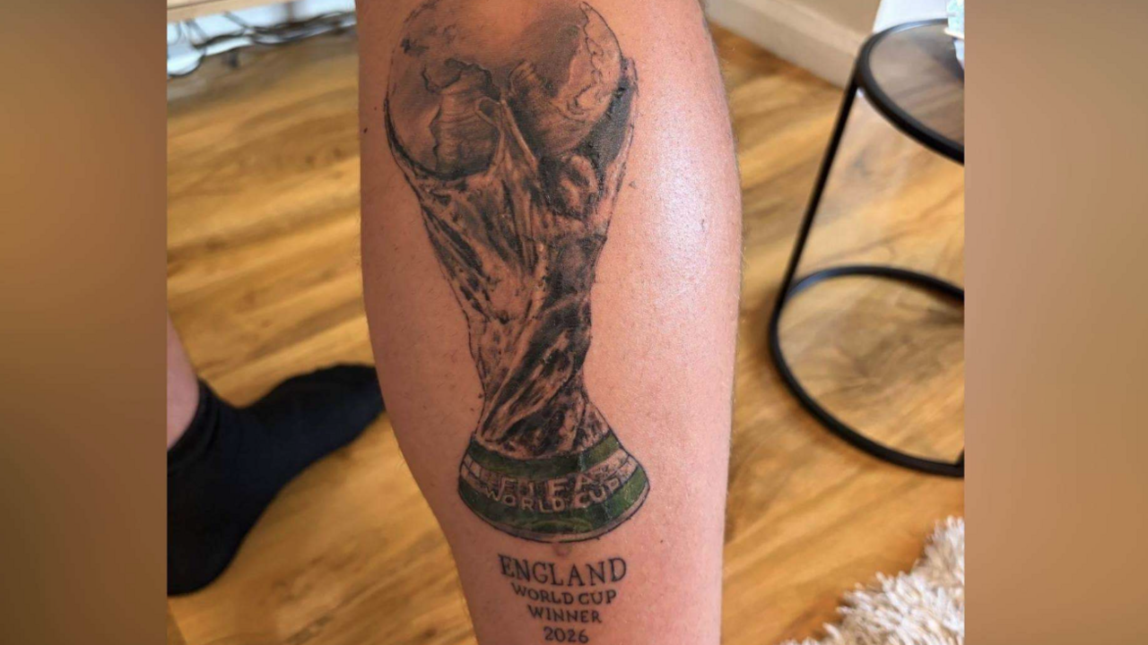A close of Sean's tattoo on the back of his calf, showing the World Cup trophy and the words "England World Cup winner 2026" in capitals underneath