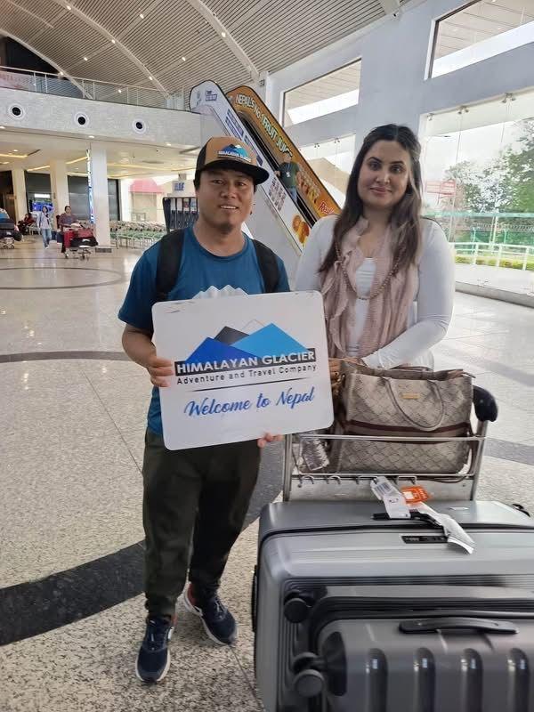 Geetha Reddy stands next to a tour guide in Nepal inside an airport