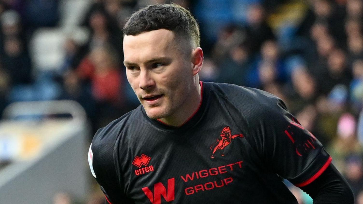 Macaulay Langstaff, wearing Millwall's black and red away kit, celebrates a goal against Sheffield Wednesday in February 2026