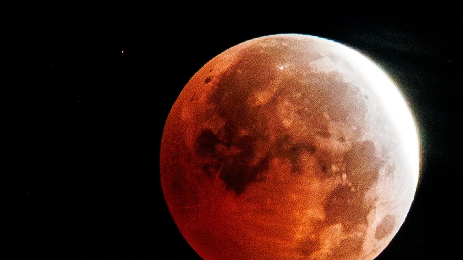Full moon with a red tinge over the majority of the Moon