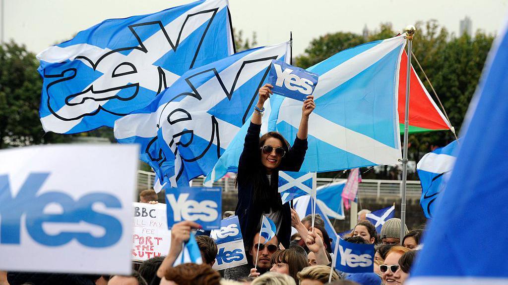 people holding yes banners and flags