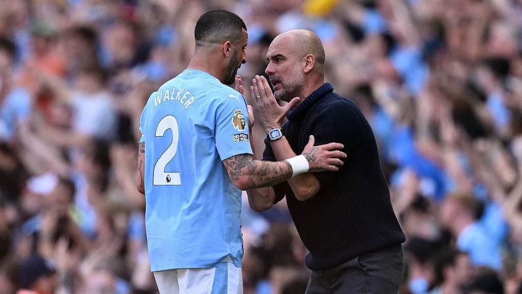 Kyle Walker and Pep Guardiola have a discussion on the touchline.