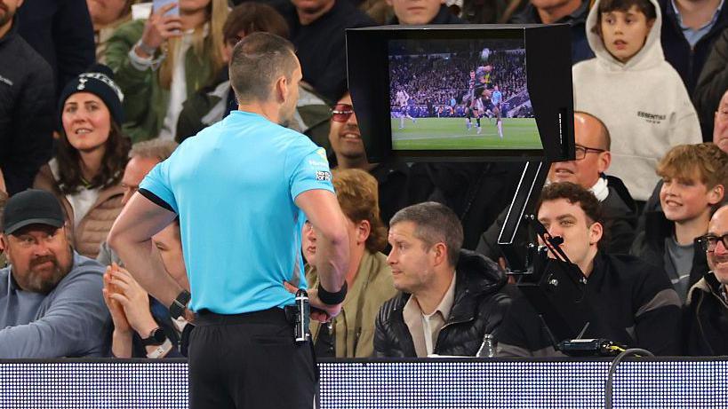 Referee Jarred Gillett reviews the VAR monitor during the Premier League match between Tottenham Hotspur and Leeds United
