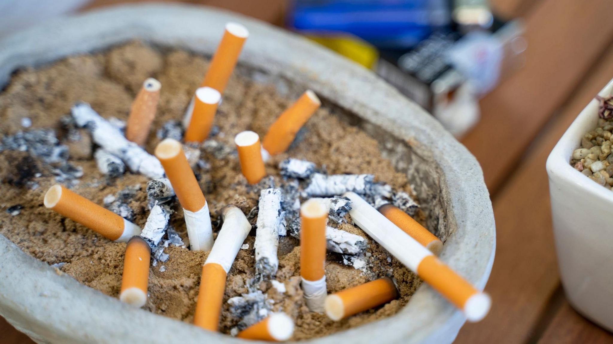 An ash tray containing lots of cigarette butts
