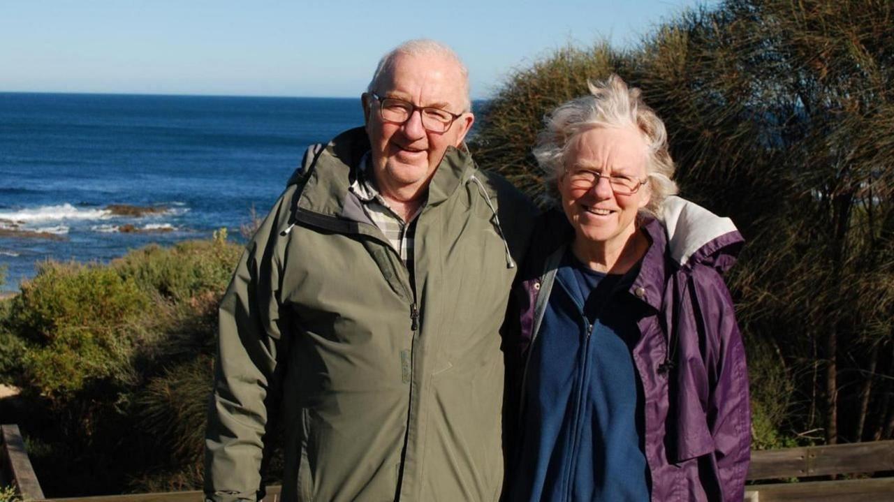 Don and Gail Patterson look at the camera with a sea background