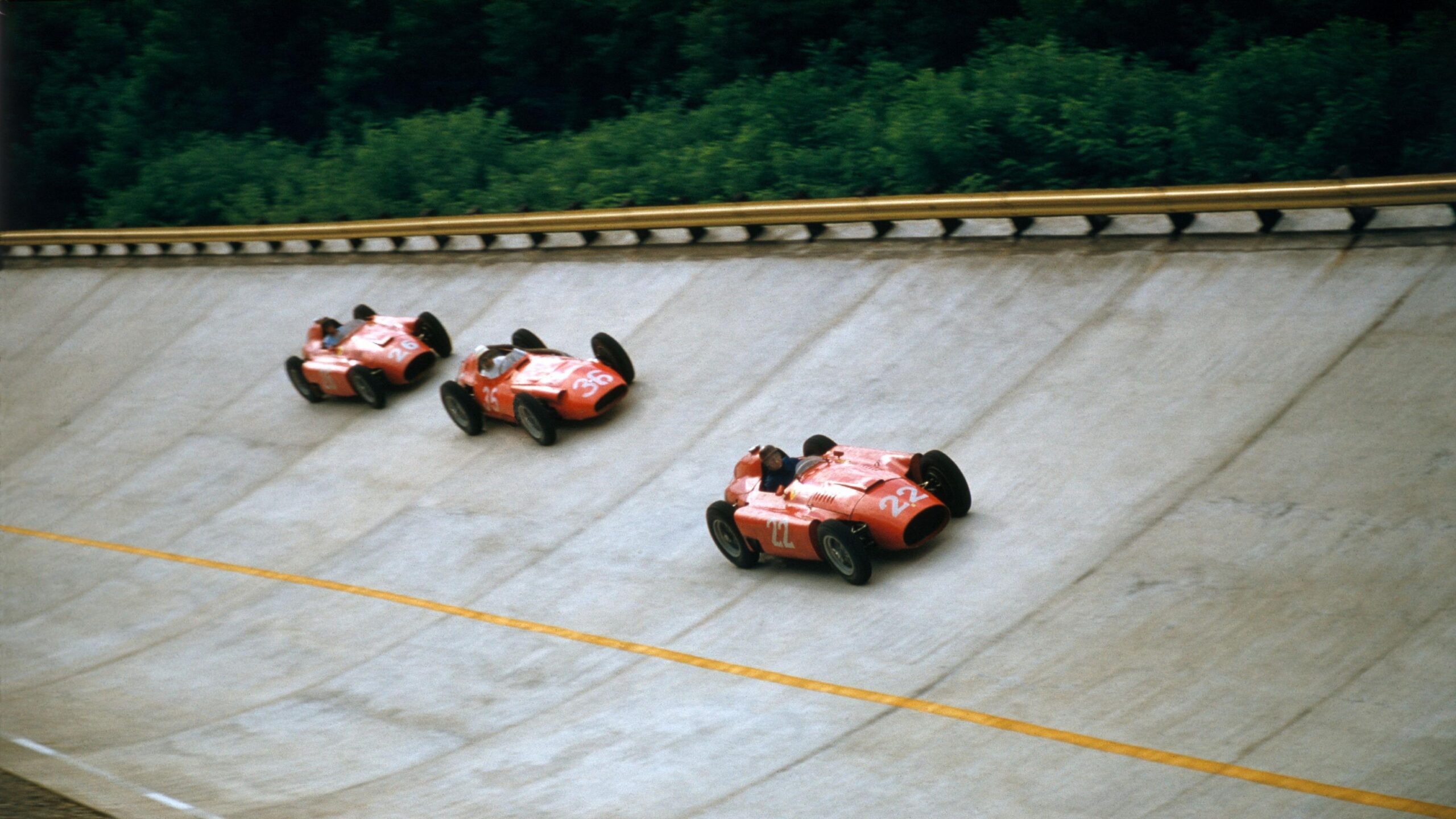 Ferrari's Juan Manuel Fangio followed by Maserati's Stirling Moss and Ferrari's Peter Collins on the banking during the 1956 Italian Grand Prix