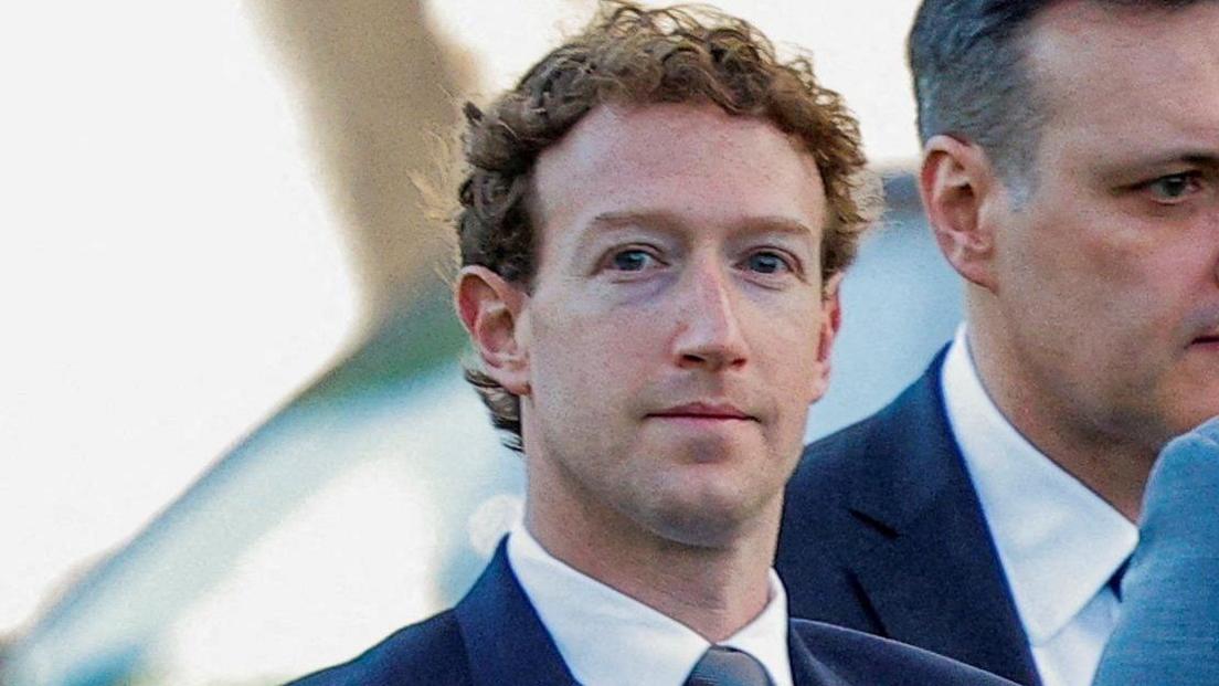 Meta CEO Mark Zuckerberg looking at a camera while walking into a Los Angeles courthouse, wearing a blue suit, tie and white shirt.