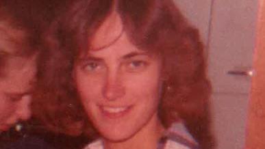 Karen Schepers smiles at the camera, her brown wavy hair split in the middle in a typical early-1980s style