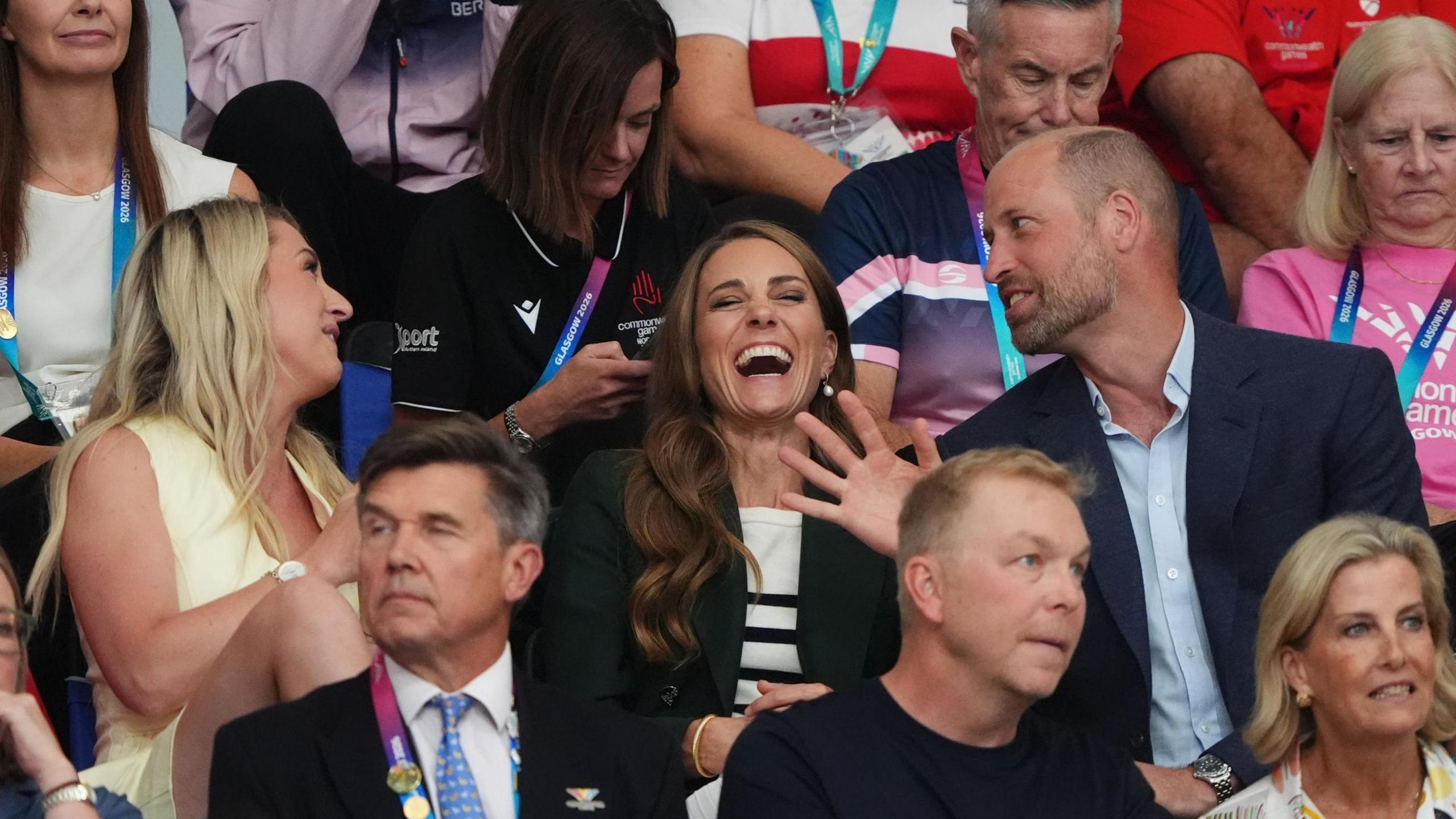 The Prince and Princess of Wales laughing in a crowd of spectators with British cyclist Laura Kenny. Chris Hoy sits in the row in front of them.