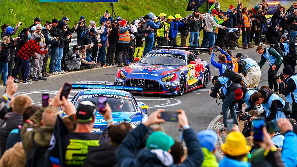 Photographs take picture of Max Verstappen's car as he competes in the 24h Race at Nurburgring in may