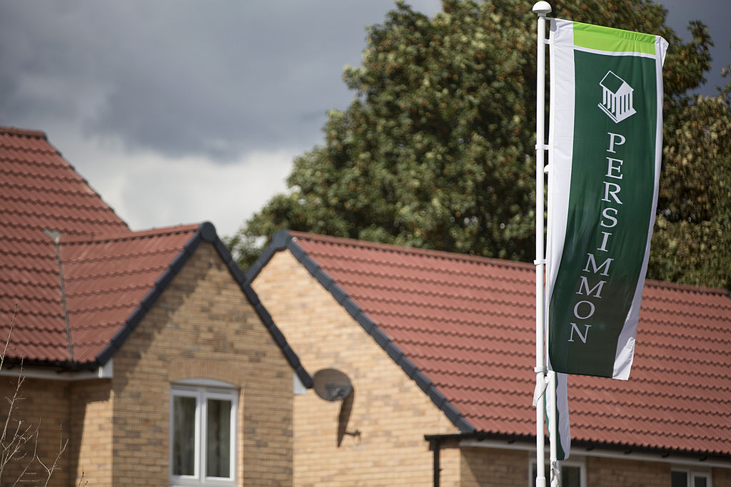 Persimmon logo sits on a green banner as it flies near newly constructed houses