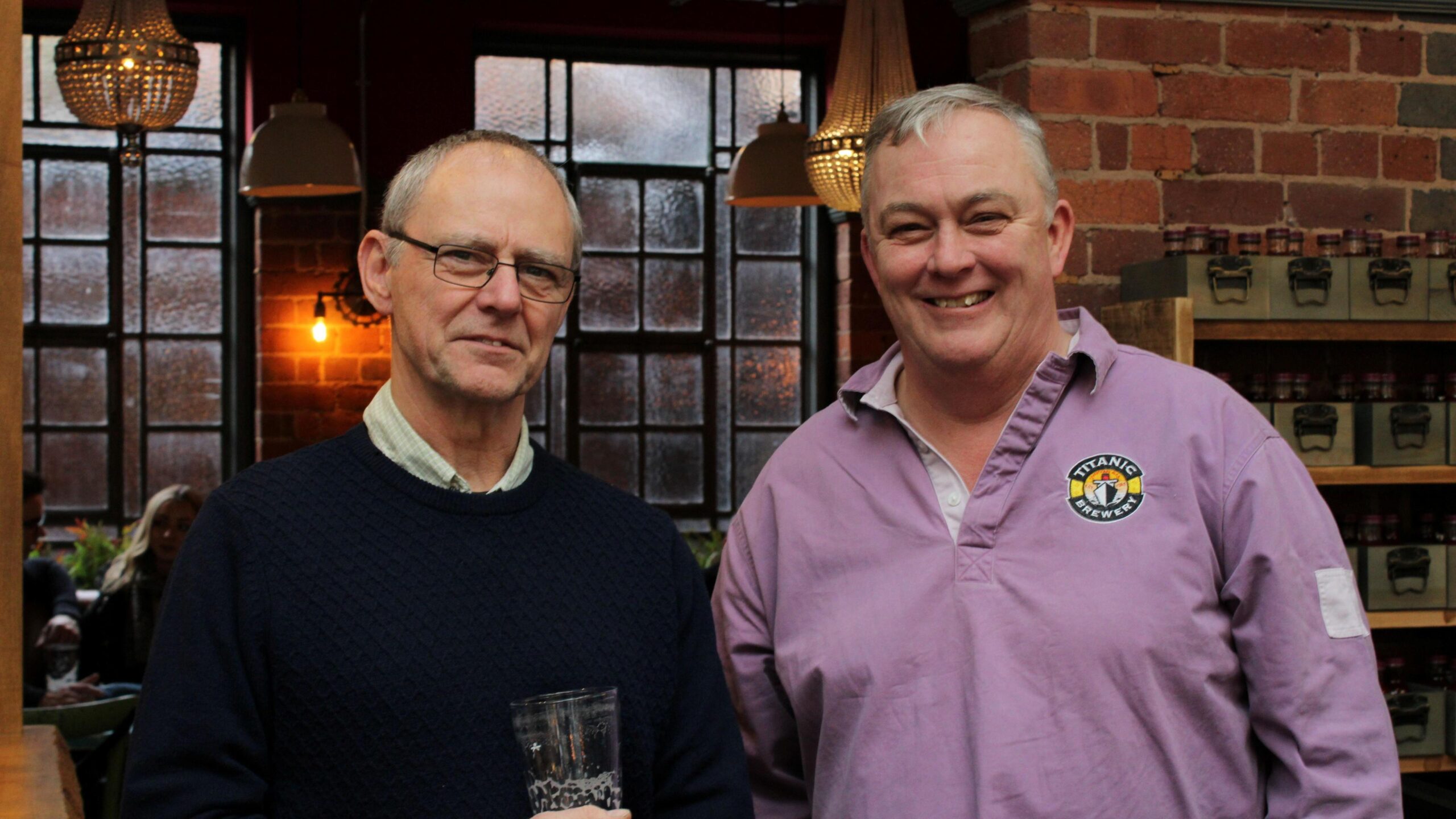 Keith Bott wears a pink rugby shirt and stands alongside his co-owner Dave Bott outside one of the Titanic group's pubs.