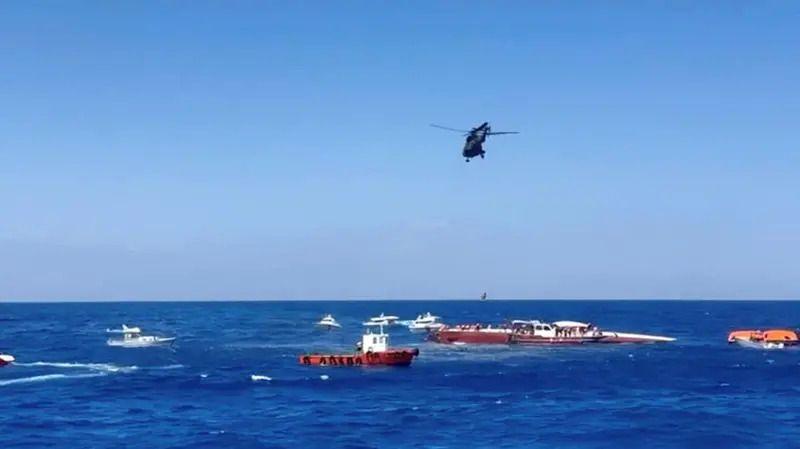 Several boats and a helicopter offer aid to a sinking a boat close to the Northern Cypriot port of Kyrenia.