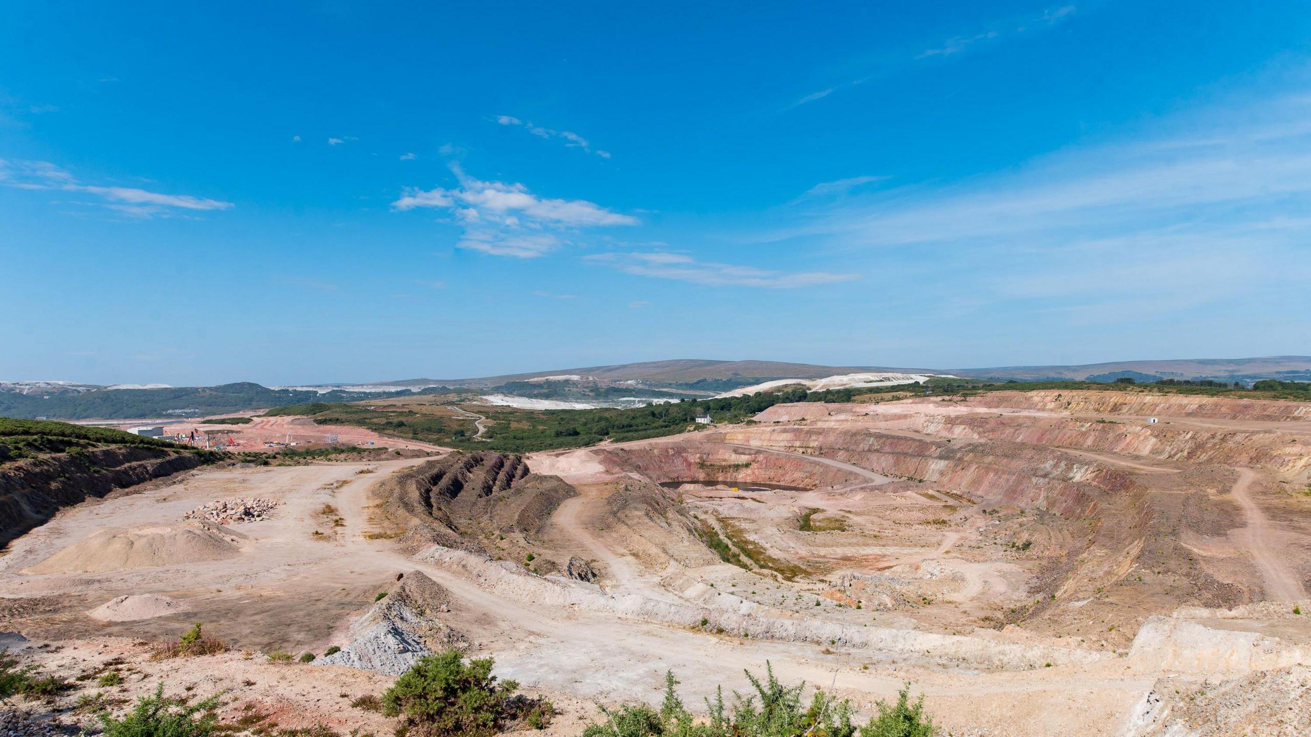A wide view of Hermerdon mine in Devon. The land is light brown with dark patches and is deep.