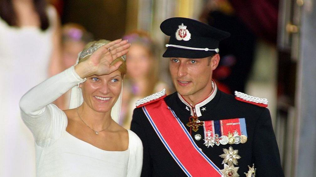 Then-Crown Princess Mette-Marit (L) and then-Crown Prince Haakon on the wedding day in August 2001. He is dressed in military regalia, she is wearing a traditional, white dress.