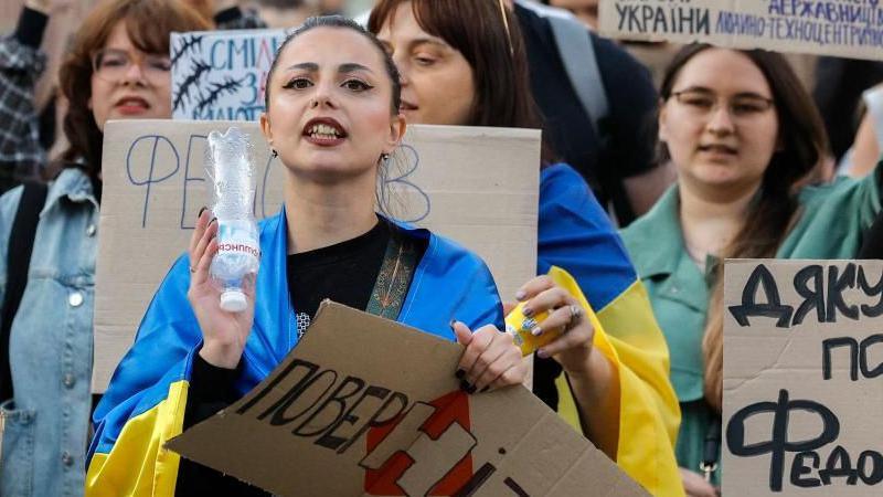 A young woman protester in Ukraine draped in a blue and yellow flag