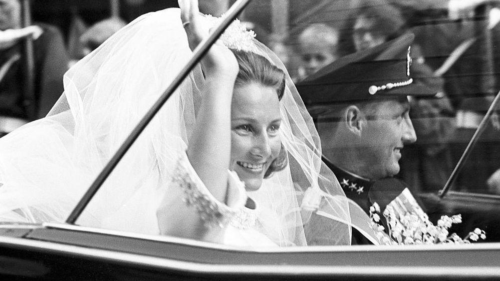 A picture taken on August 29, 1968 shows Norway's Crown Prince Harald and Sonja Haraldsen waving as they leave in their car the Oslo Cathedral during their wedding ceremony.