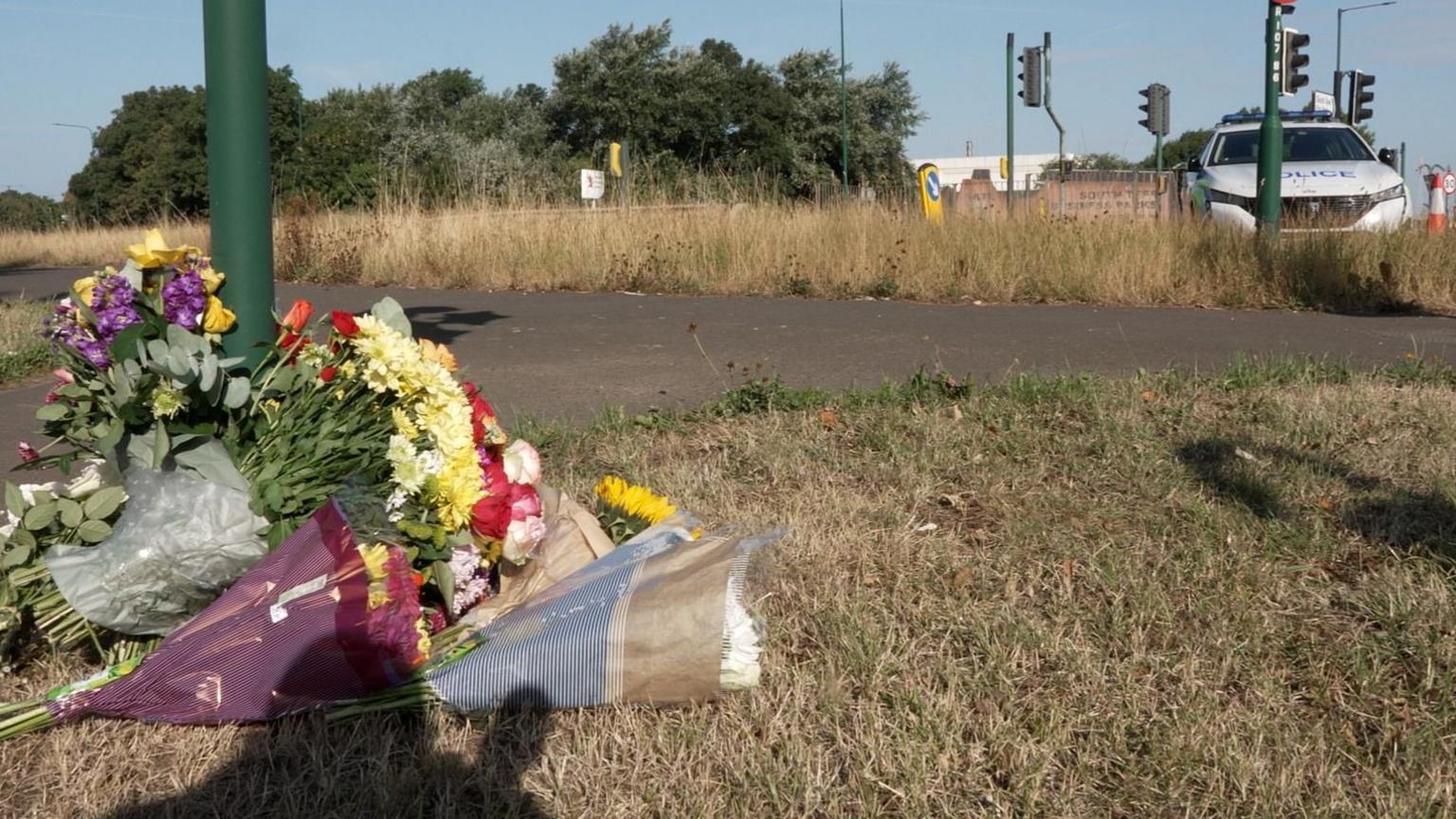 Flowers left near to the scene on the A66 in South Bank, near Middlesbrough following a fatal crash. The flowers are attached to the bottom of a lamppost A police car is in the background.