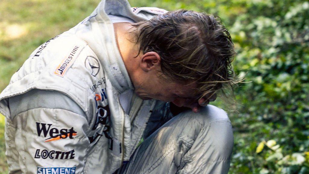 McLaren's Mika Hakkinen in crouched over with his hand over his face and in tears after spinning off while in the lead of the 1999 Italian Grand Prix
