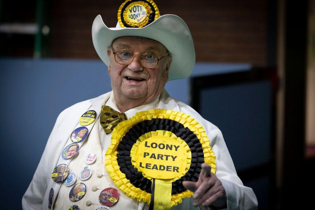 Howling Laud Hope, leader of the Monster Raving Loony party, clad in a white suit and cowboy hat decorated with buttons and a large rosette