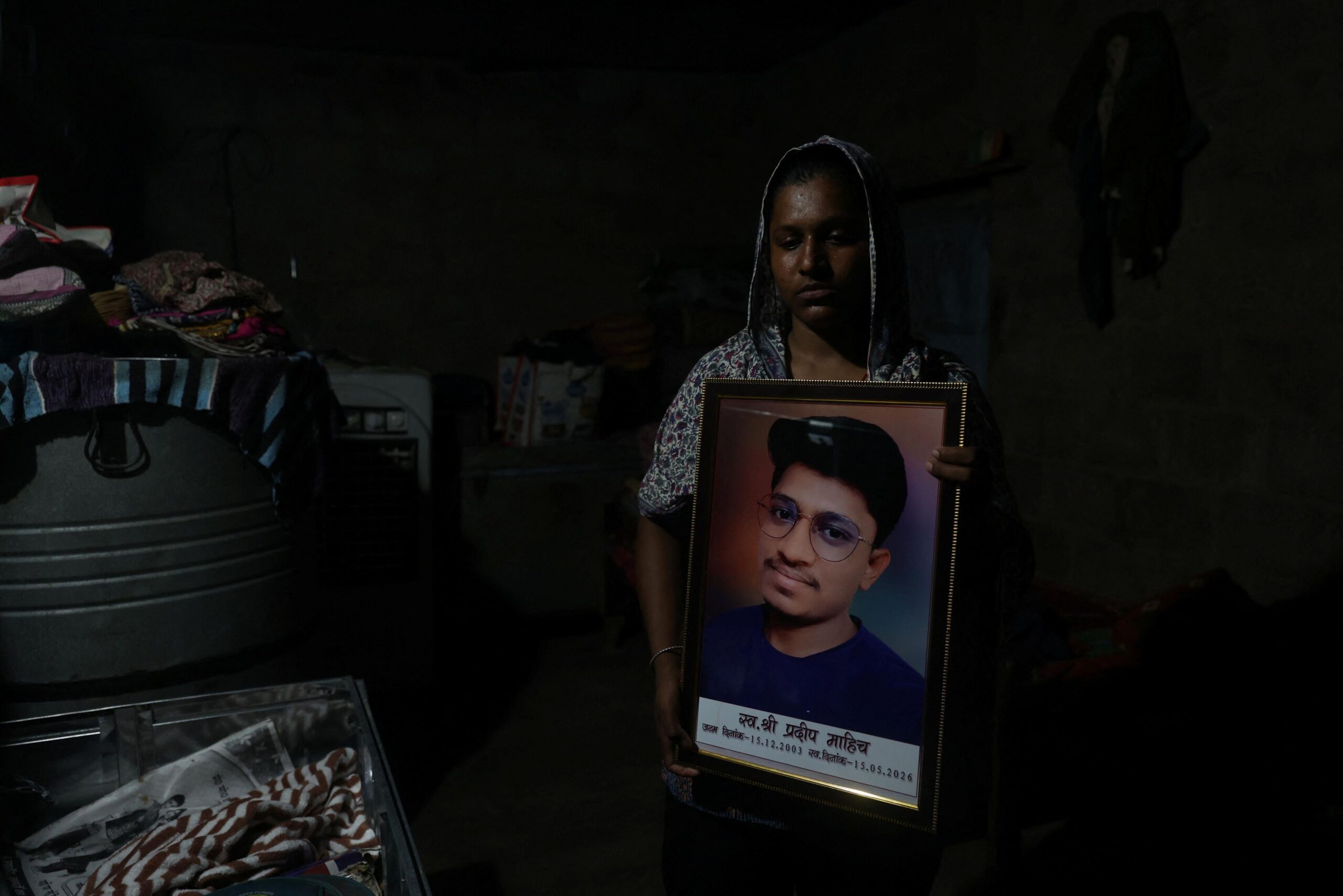 Babita Kumari, sister of Pradeep Kumar, 22, an aspirant doctor who took his own life after the results of the first NEET exam were cancelled, poses for a picture as she holds a photo of her brother at her home in Jhunjhunu, India, July 21, 2026. REUTERS/Francis Mascarenhas