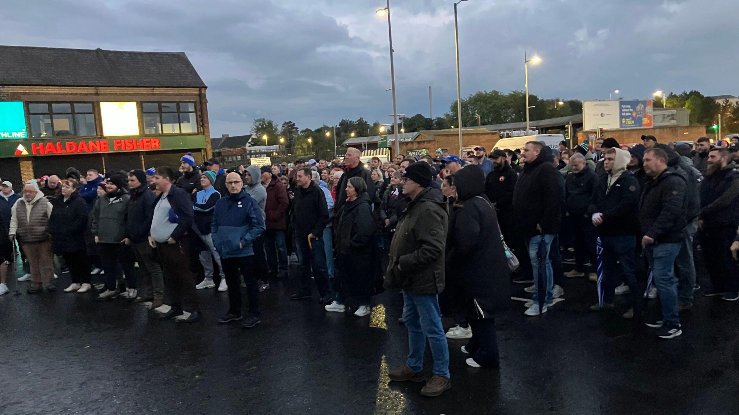 A crowd of people gather together on a road.